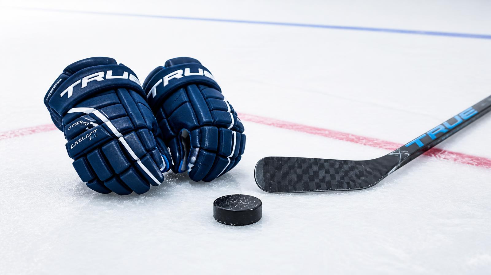 Hockey gloves and stick resting on fresh white ice under rink lighting